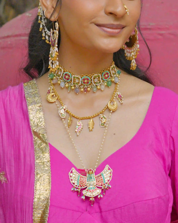 Woman wearing traditional gold jewelry with a pink blouse