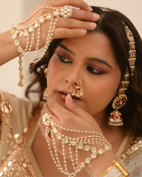 Woman wearing traditional jewelry with a focus on her face and hands.